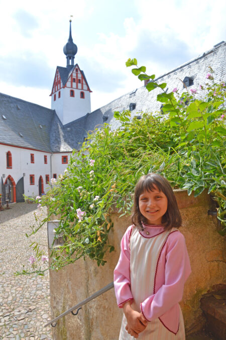 Burghof Schloss Rochsburg, Kleines Mädchen im pinkfarbigen Burgfräulein-Kleid
