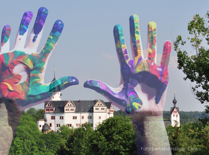 Bunt bemalte Hände, im Hintergrund Schloss Rochsburg